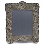 Large 958 silver easel photo frame profusely embossed with Putti and figures amongst flowers and
