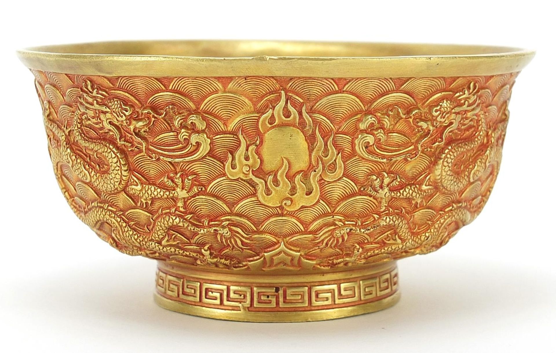 Chinese gilt bronze footed bowl cast with dragons amongst clouds chasing flaming pearls, four figure