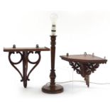 Two carved mahogany shelf brackets and a table lamp, the largest 40cm high