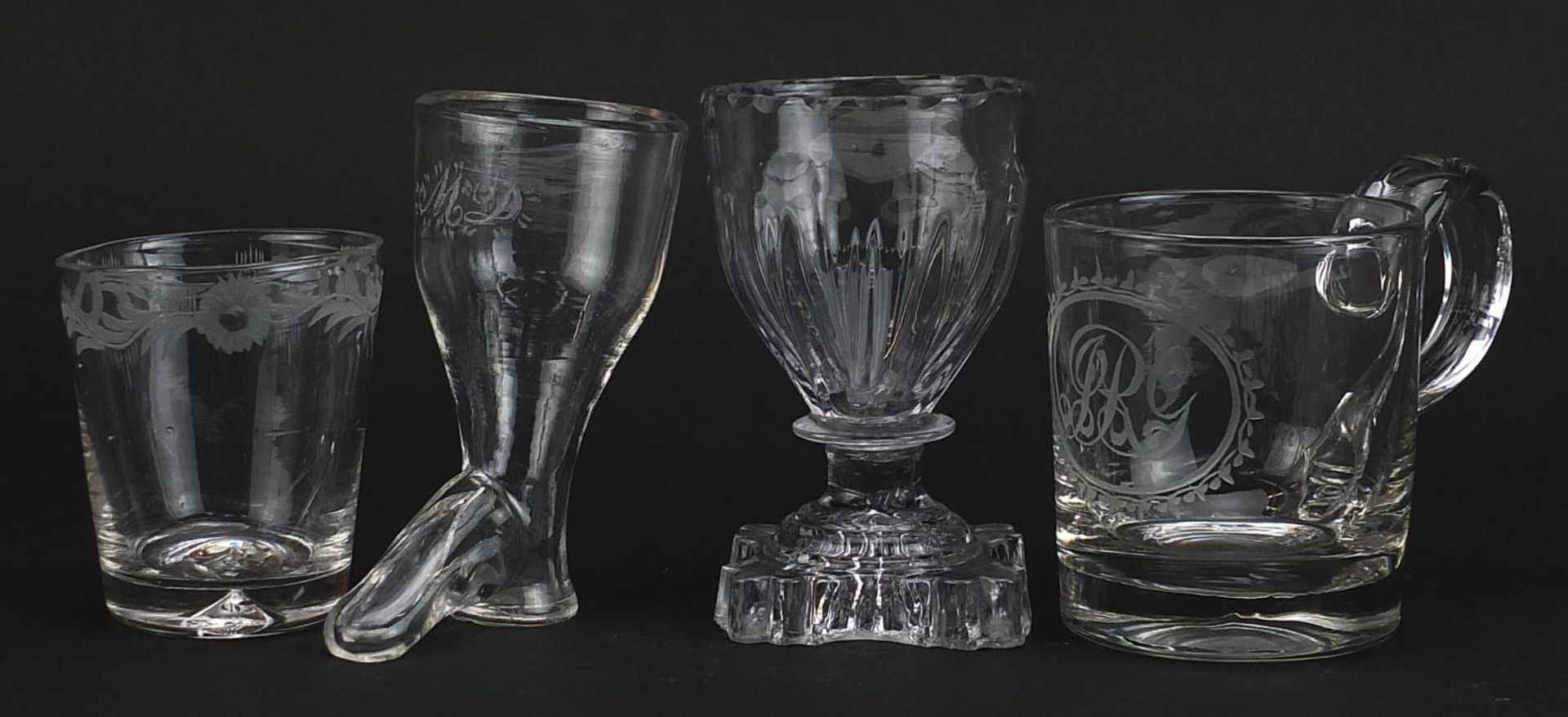 Four 18th century glasses including a stirrup cup and handled cup with engraved initials, the