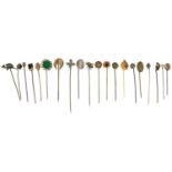 Twenty Victorian and later stickpins including spider, coin, helmet and floral examples, the largest