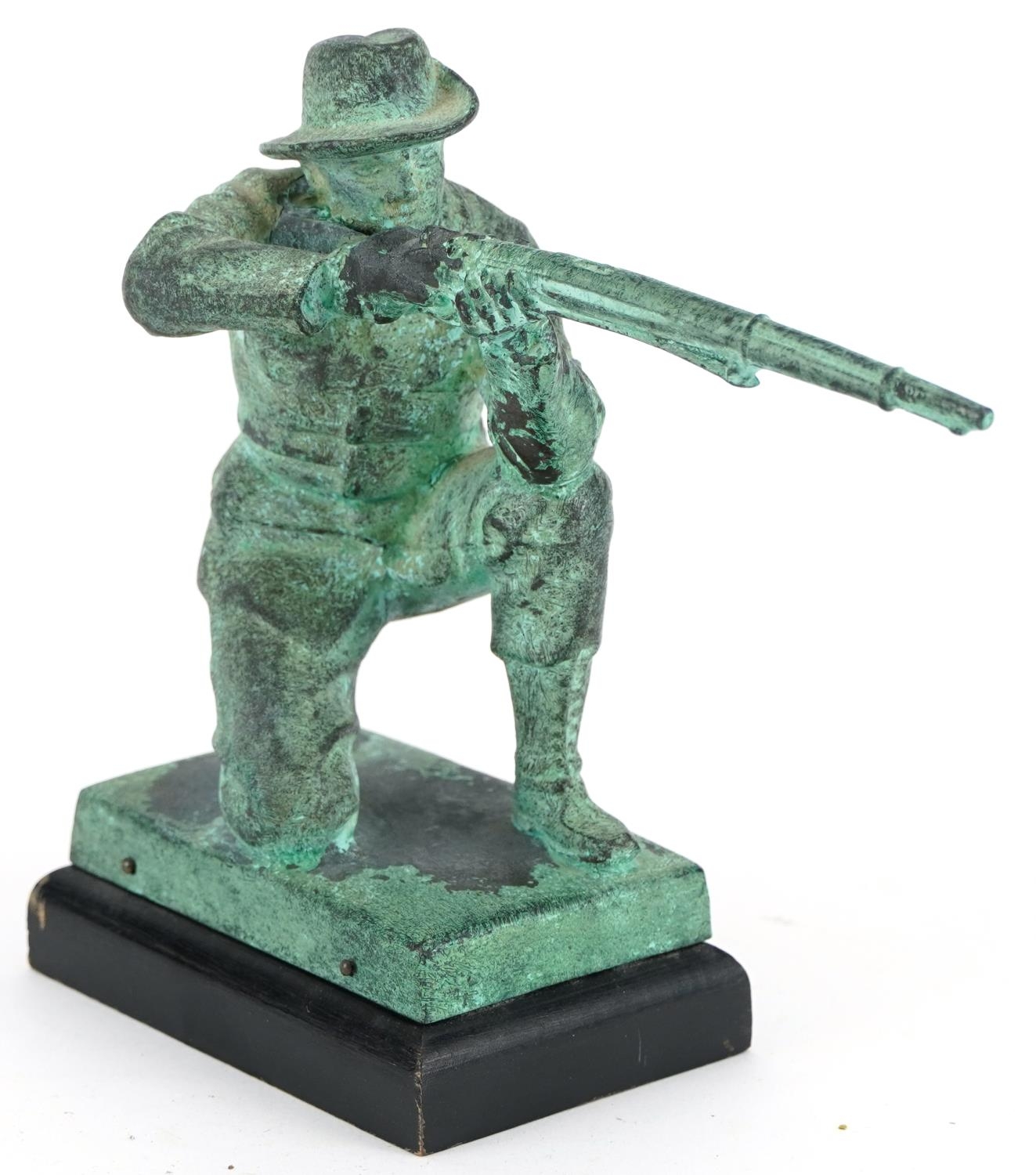 Verdigris patinated metal statue of a hunter holding a shotgun, 15cm high