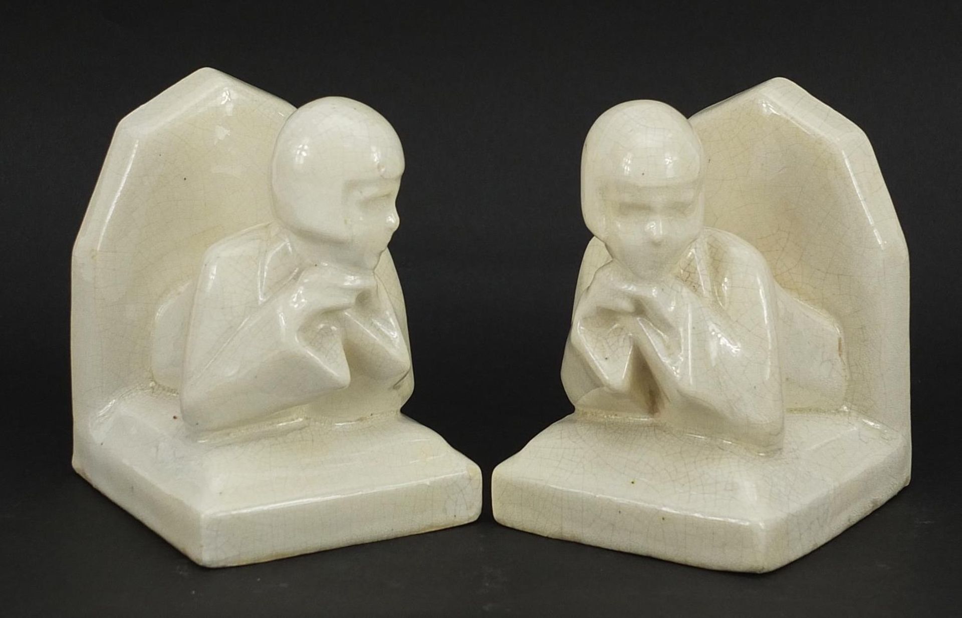 Pair of Art Deco cream glazed bookends in the form of females, 10.5cm high