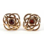 Pair of 9ct gold Celtic design stud earrings set with a red stone, 1cm in diameter, 1.2g