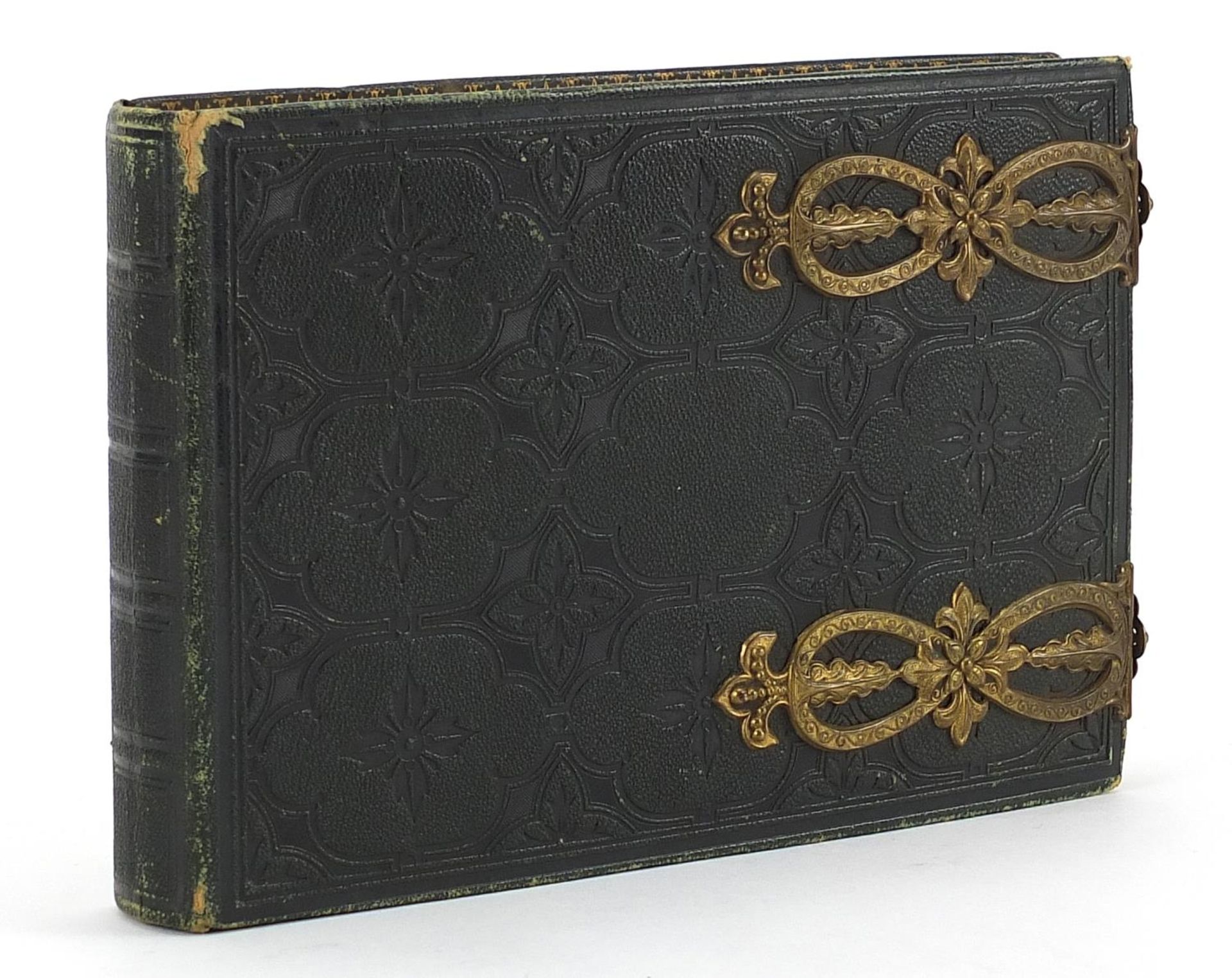 Collection of black and white cabinet cards and greetings cards arranged in a tooled leather album