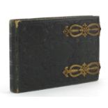 Collection of black and white cabinet cards and greetings cards arranged in a tooled leather album