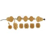 Six carved bone floral pendants and a carved bone ethnic bracelet, the largest pendant 5cm