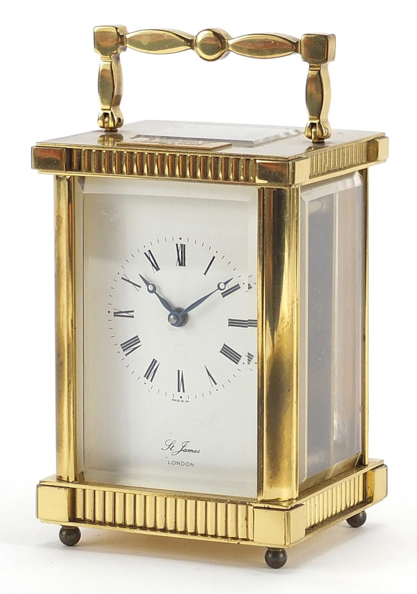 St James brass cased carriage clock with enamelled dial having Roman numerals, 11.5cm high