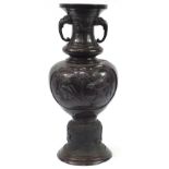 Large Japanese floor standing patinated bronze vase with twin handles decorated in relief with