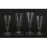 Four 18th century ale glasses including three etched with flowers and berries, two with folded foot,