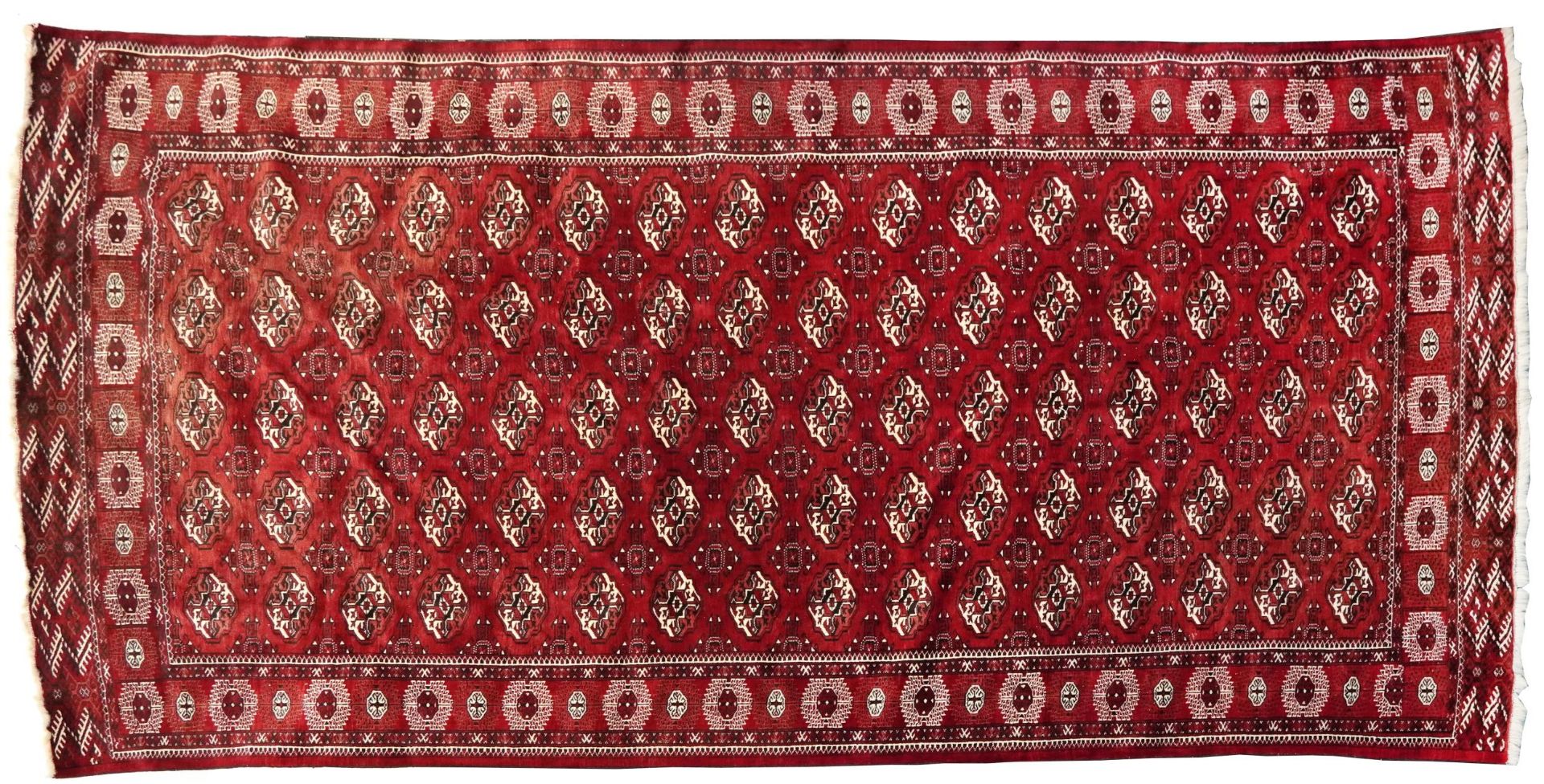 Rectangular Persian Turkmen red ground carpet having an all over geometric design, 345cm x 215cm