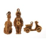 Three 9ct gold charms comprising violin, figure and scooter, the largest 2.4cm high, 2.1g