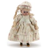 Miniature bisque headed doll with open mouth and opening and closing eyes, 15cms high