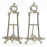 Pair of Rococo style silvered metal easel stands, 40cm high