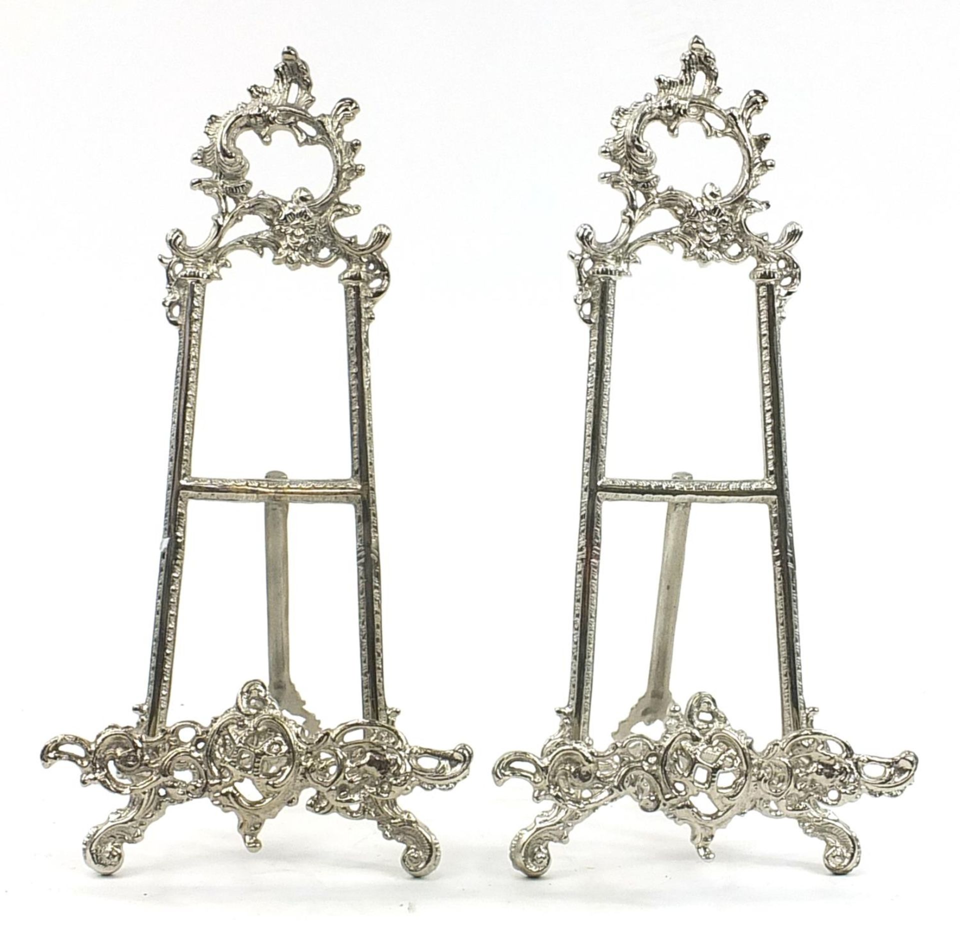Pair of Rococo style silvered metal easel stands, 40cm high
