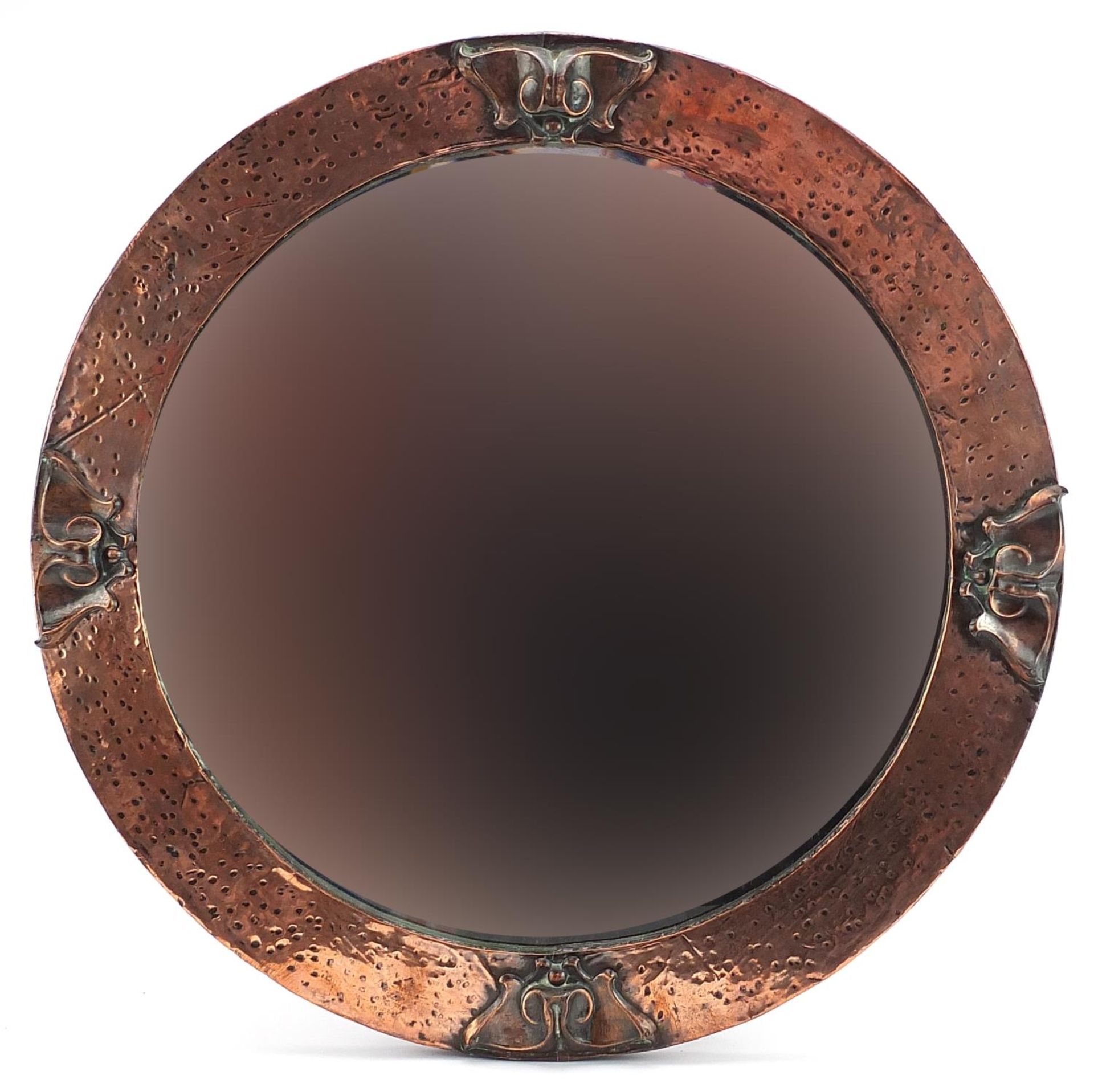 Manner of Liberty & Co, Arts & Crafts beaten copper wall mirror with bevelled glass plate, 49.5cm in