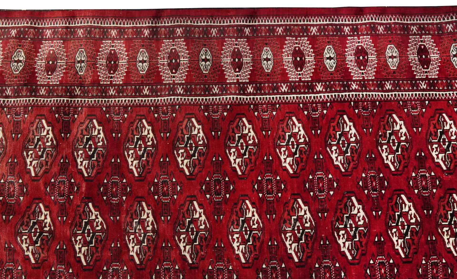 Rectangular Persian Turkmen red ground carpet having an all over geometric design, 345cm x 215cm - Image 3 of 8