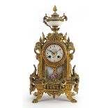 French gilt metal mantle clock with enamelled dial and Sevres style panel hand painted with a