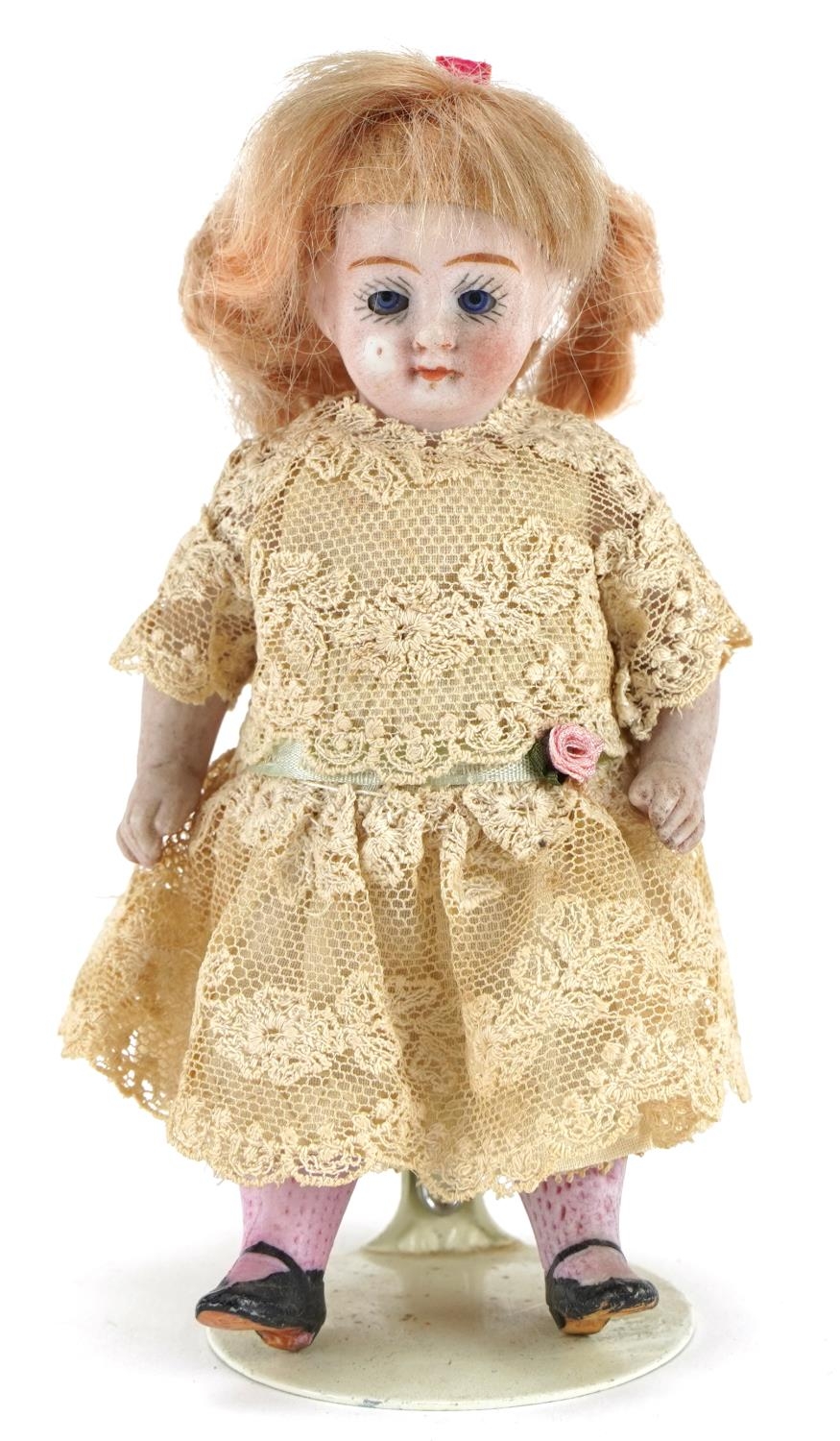 Miniature bisque headed doll with open mouth and opening and closing eyes, stamped 570/2, 11cms high