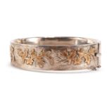 Silver hinged bangle decorated with birds amongst leaves, 6.5cm wide, 25.6g