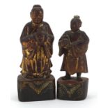 Two Chinese partially gilt lacquered wood carvings of attendants, the largest 18.5cm high