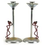 Pair of Art Deco partially painted chrome candlesticks in the form of a figure leaning against a