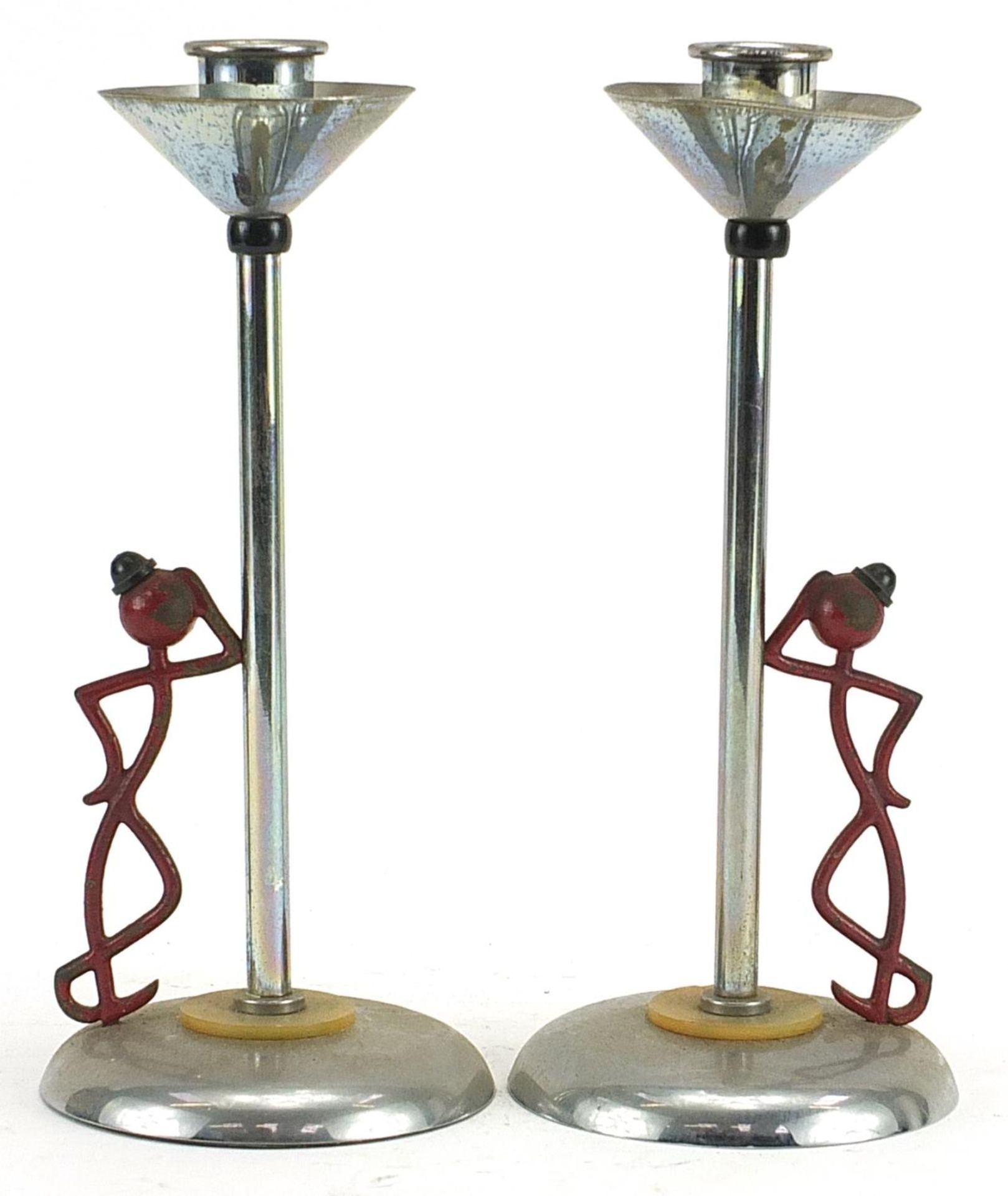 Pair of Art Deco partially painted chrome candlesticks in the form of a figure leaning against a