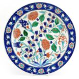 Kutahya, Turkish pottery charger hand painted with flowers, signed Saylam Ciri, 30.5cm in diameter