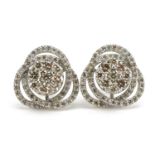 Pair of 18ct white gold swirling diamond cluster stud earrings, total diamond weight approximately