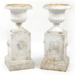 Pair of white painted campana urn planter on stands with lion masks, 92cm high
