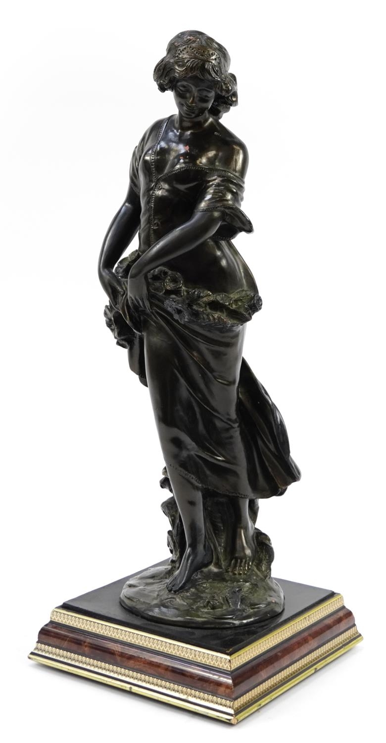 Large bronzed pottery floor standing figurine of a young female with flowers, 66cm high