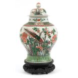 Chinese porcelain baluster vase and cover raised on carved hardwood stand, hand painted in the