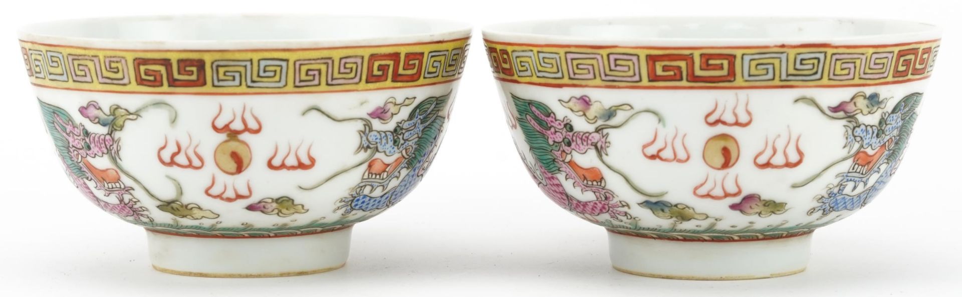 Pair of Chinese porcelain bowls hand painted in the famille rose palette with dragons chasing the