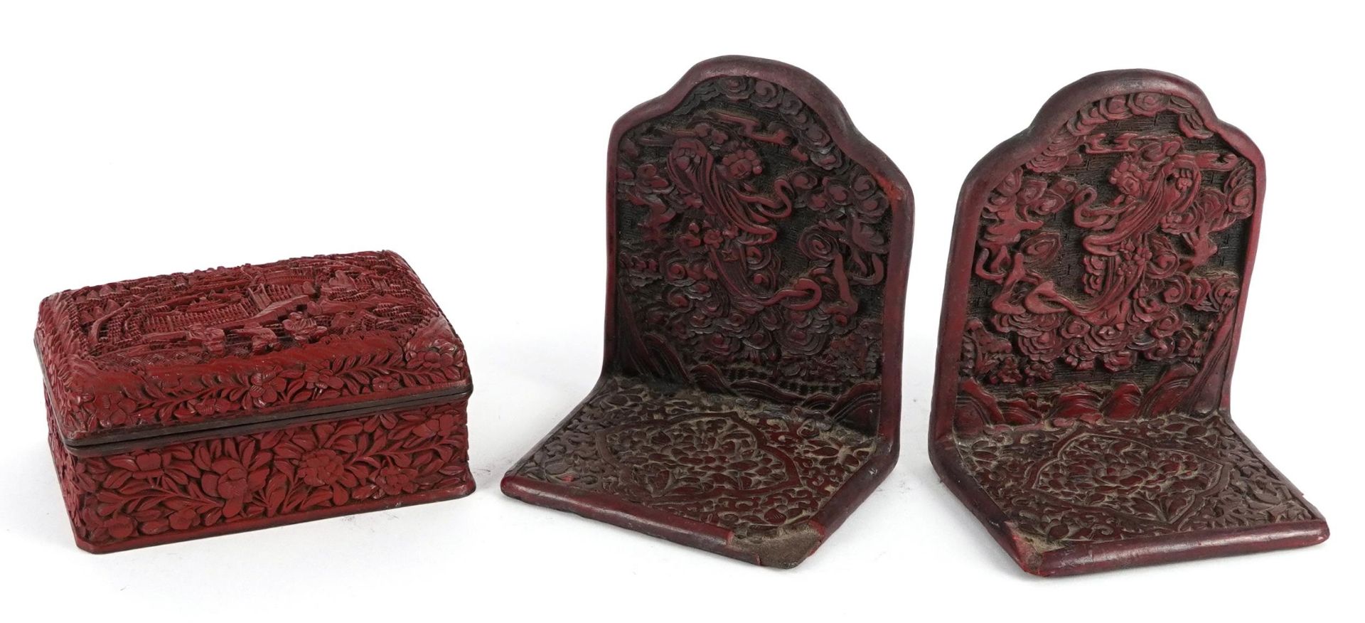 Pair of Chinese cinnabar lacquered bookends and a box and cover carved with figures in a landscape