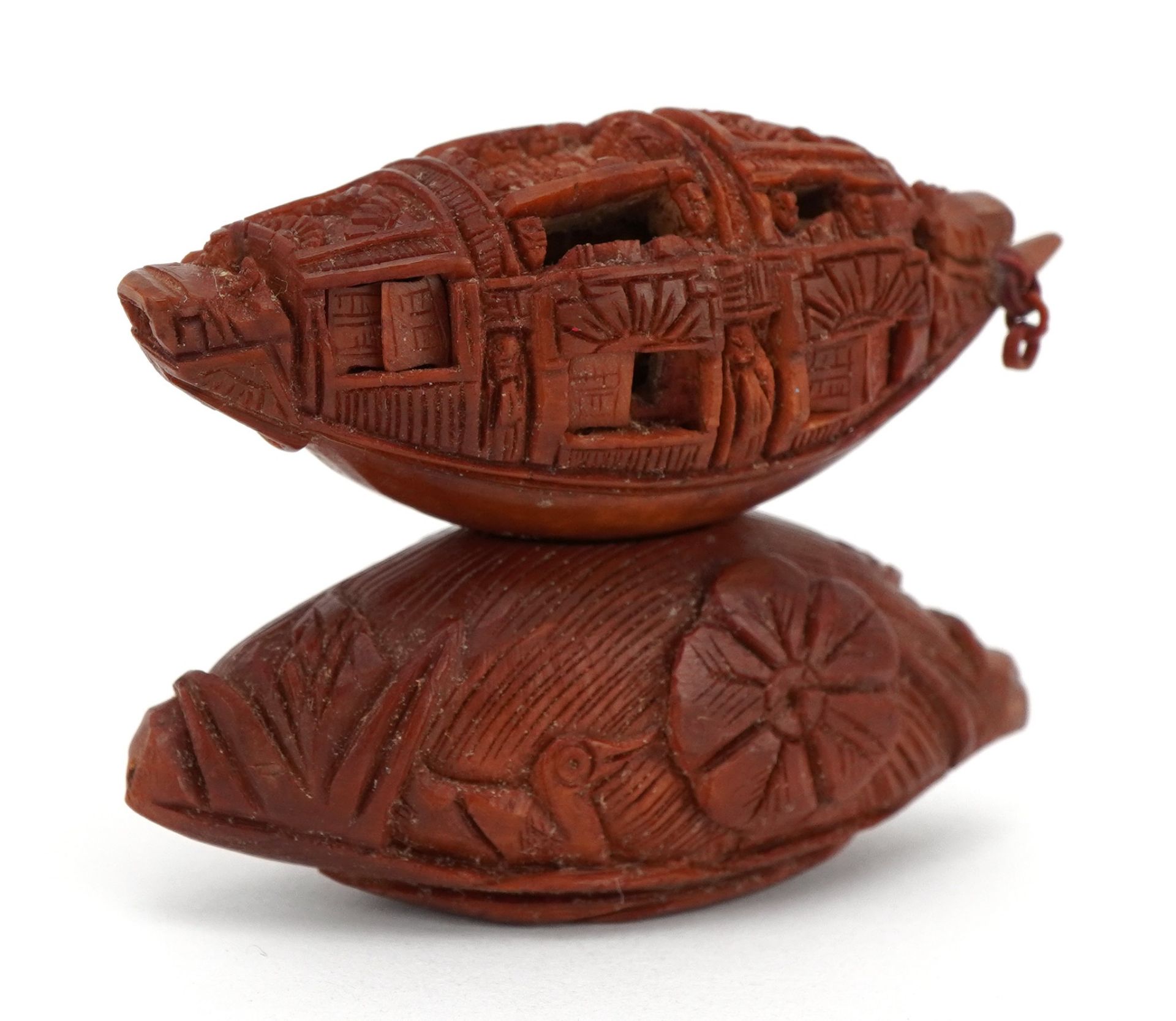 Good Chinese carved coquilla nut junk with opening windows and inscribed poem, raised on a