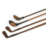 Four early 20th century wooden shafted golf clubs, the largest 109cm in length
