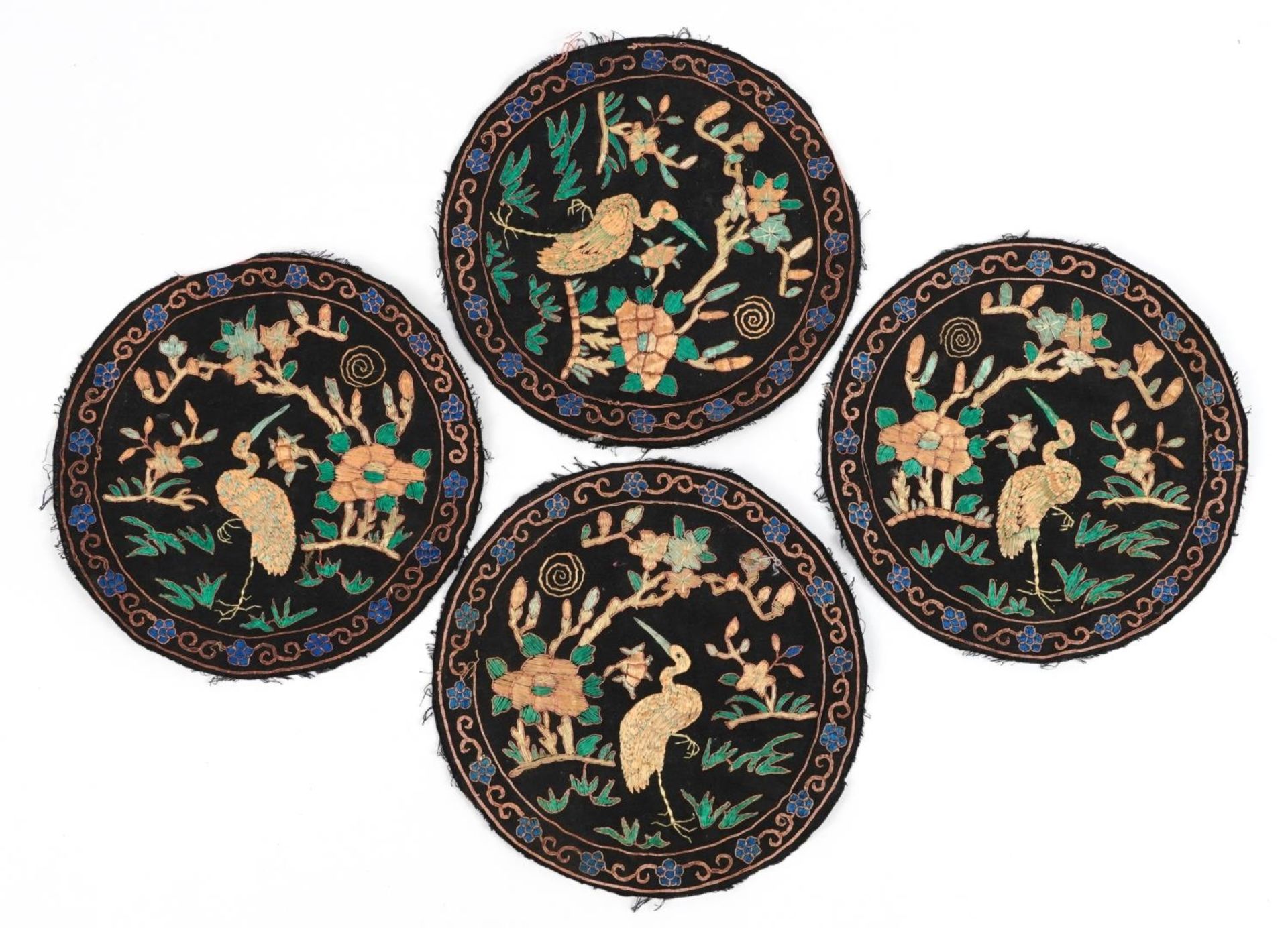 Set of four Chinese textile roundels embroidered with birds of paradise amongst flowers, each 23.5cm