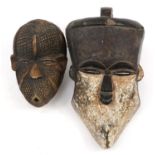 Two Tribal interest face masks including one with white paint, the largest 38cm high