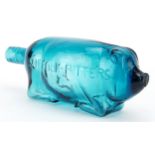 Blue glass bottle in the form of a pig advertising Suffolk Bitters, 24cm in length