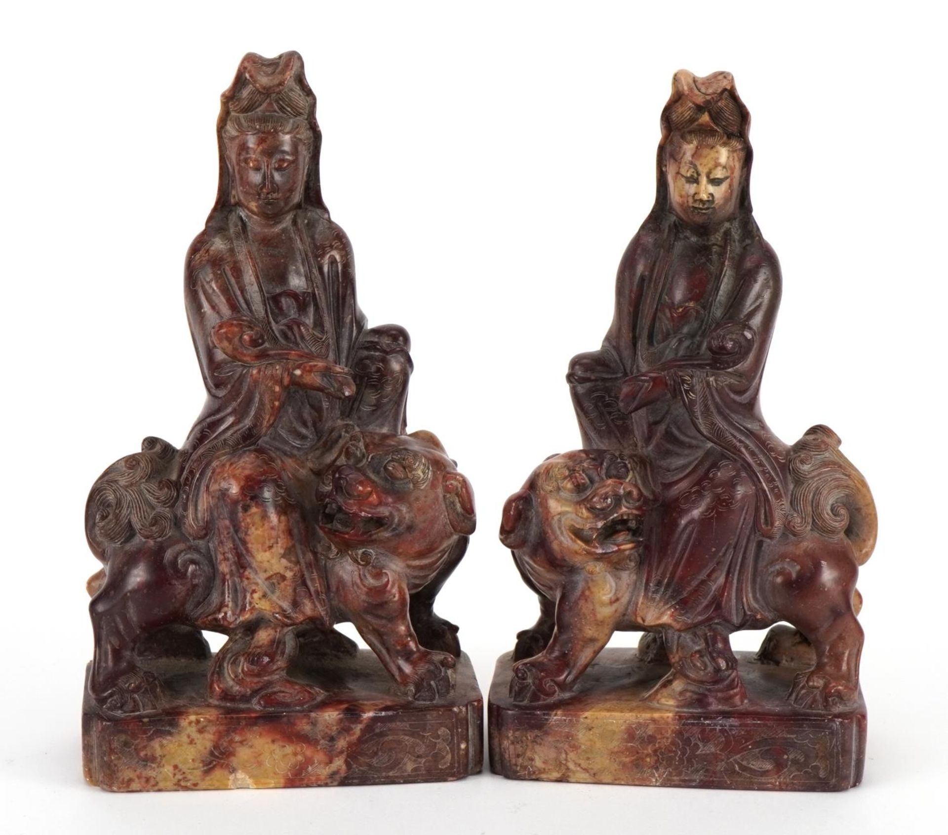 Good pair of Chinese soapstone carvings of Guanyin seated on a mythical animal, each 21cm high