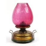 Victorian brass oil table lamp with cranberry glass shade, 41cm high