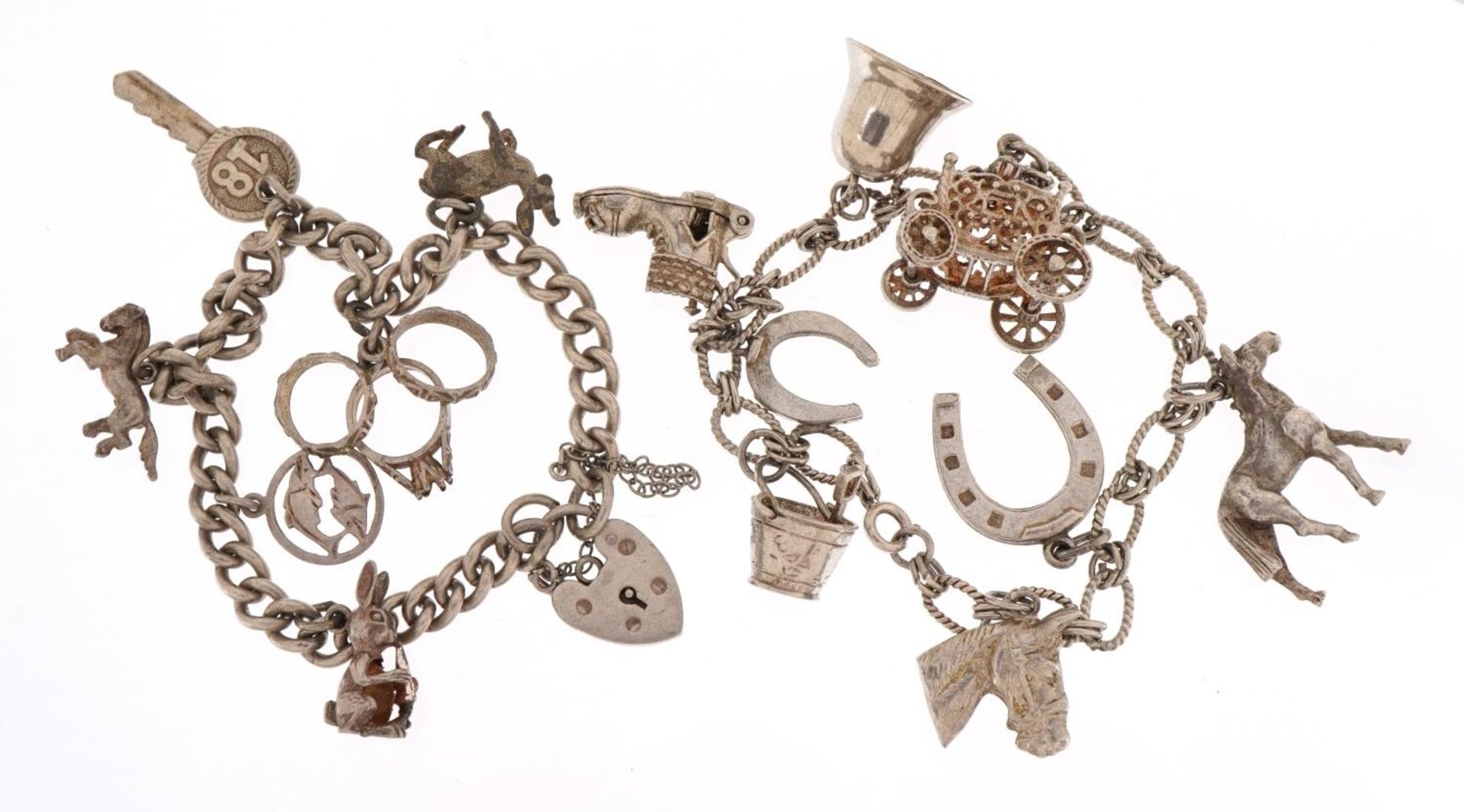Two silver charm bracelets with a selection of mostly silver charms including horsehead, carriage