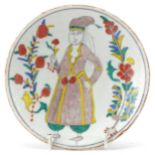Turkish Kutahya pottery dish hand painted with a figure in traditional dress and flowers, 14cm in