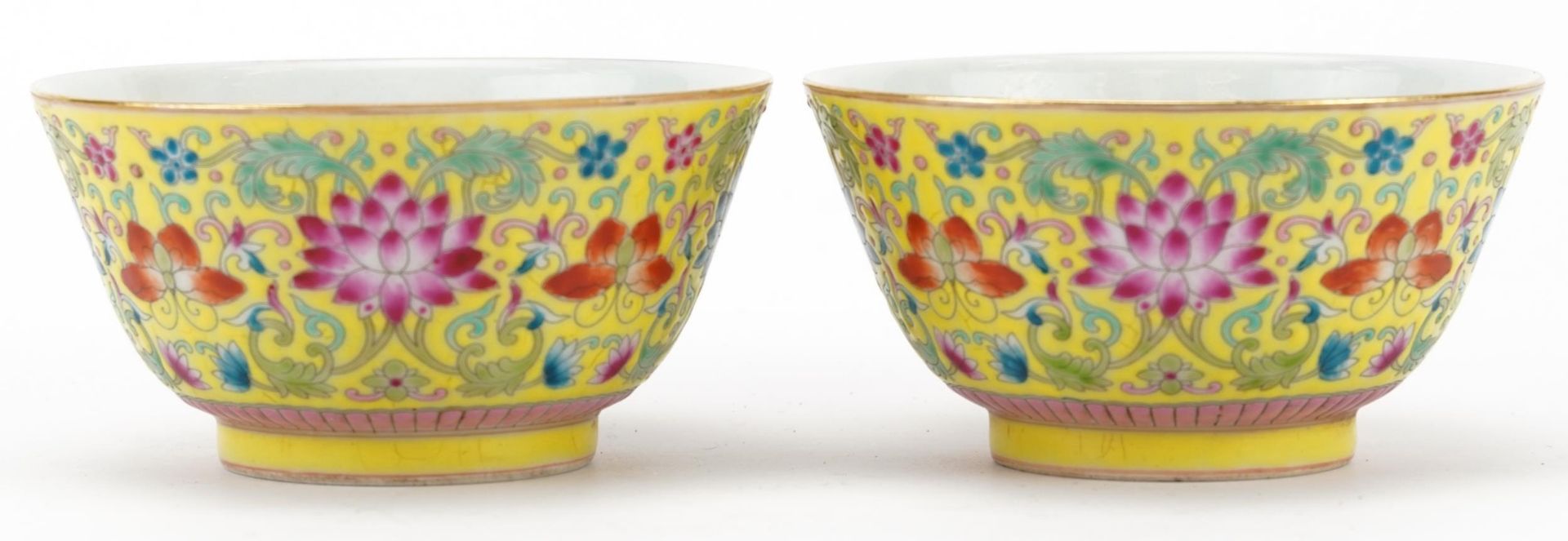 Pair of Chinese porcelain yellow ground bowls hand painted with flowers, four figure character marks