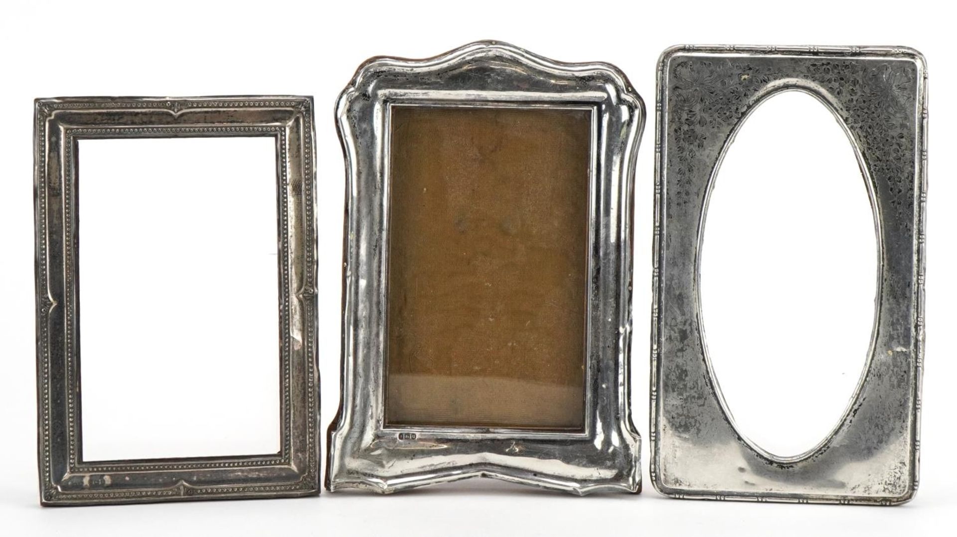 Three silver mounted photo frames, various hallmarks, the largest 18cm x 12.5cm