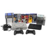 PlayStation 1 and PlayStation 2 Slimline games consoles with controllers and a collection of games