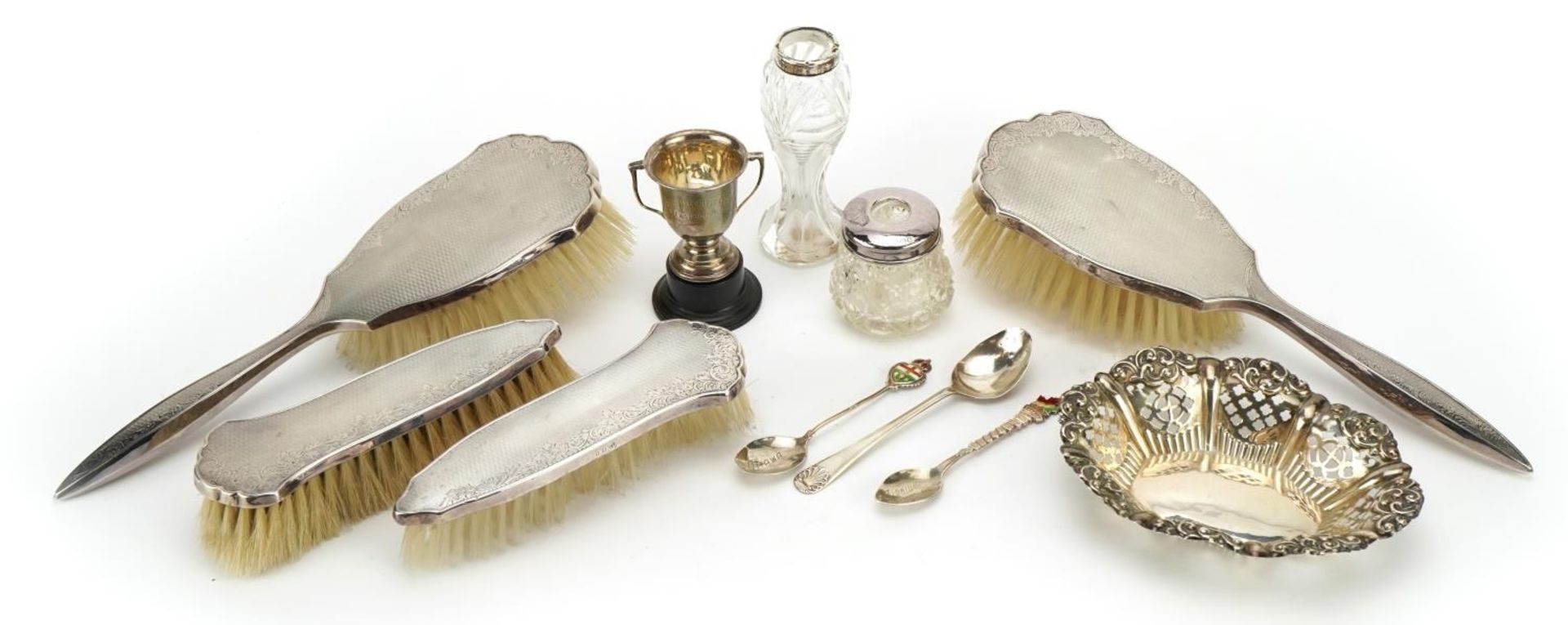 Silver items including a four piece dressing table set by W I Broadway & Co, miniature trophy with