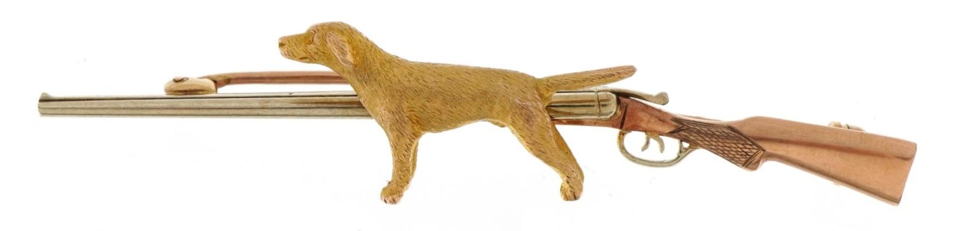 Hunting interest 9ct three tone gold shotgun and dog bar brooch, 6.4cm wide, 7.1g