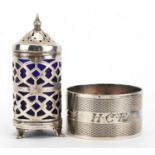 Circular silver napkin ring with engine turned decoration and a silver caster with blue glass liner,