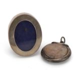 Miniature oval silver easel photo frame and a circular silver compact pendant, the largest 4.5cm